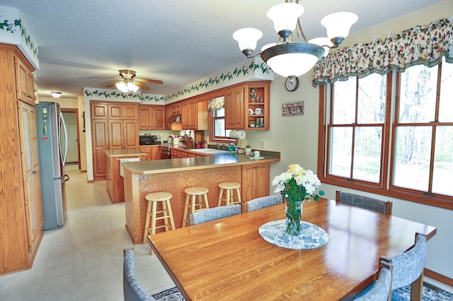 127 County Rd W, Pleasant Valley Twp, WI 54022 - dining space with radiator heating unit, a ceiling fan, light floors, and a textured ceiling