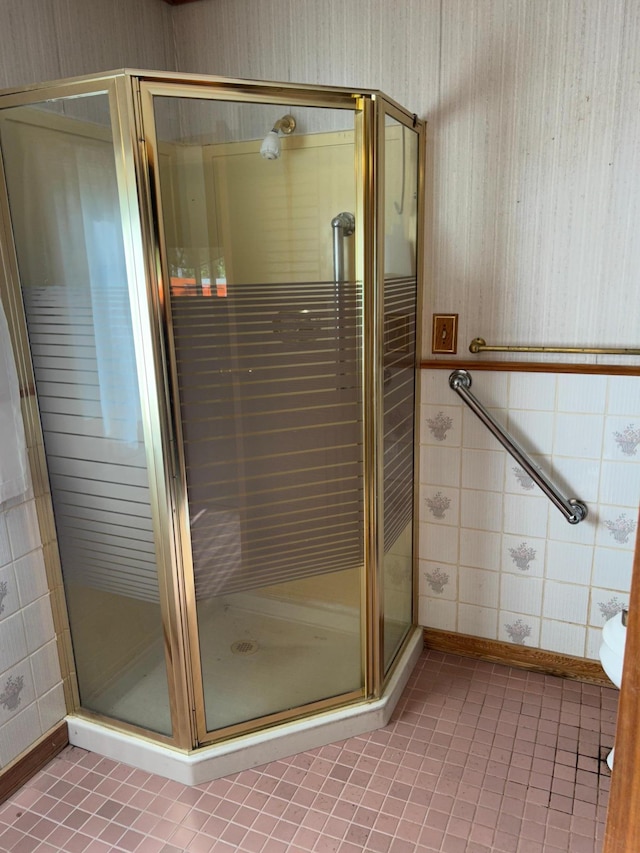 25622 Blue Bonnet Rd, Center Twp, MN 56465 - bathroom featuring wallpapered walls, a shower stall, tile patterned floors, and tile walls