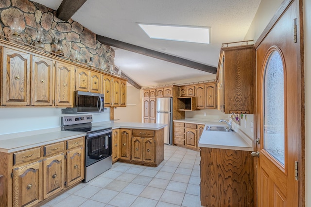 kitchen featuring appliances with stainless steel finishes, a peninsula, a sink, light tile patterned floors, and brown cabinetry