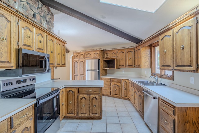 kitchen with appliances with stainless steel finishes, a sink, brown cabinetry, a peninsula, and light countertops