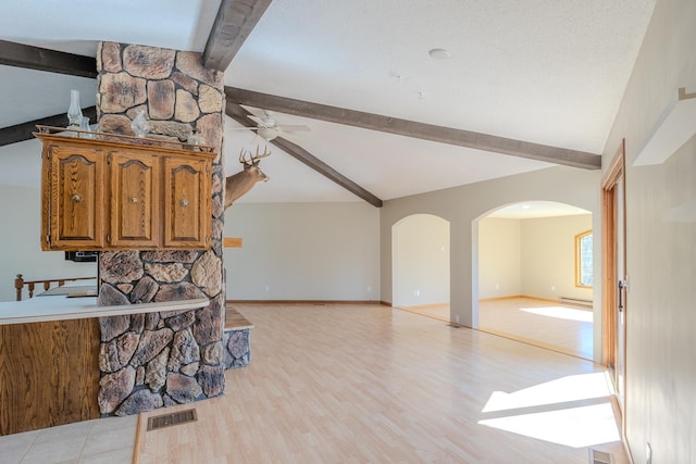 living room featuring arched walkways, ceiling fan, baseboard heating, light wood finished floors, and baseboards