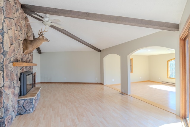 unfurnished living room featuring a baseboard heating unit, wood finished floors, a ceiling fan, and arched walkways