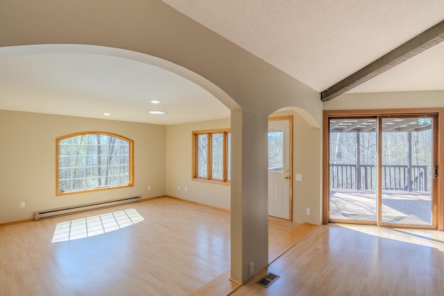 unfurnished room with a baseboard heating unit, light wood-style flooring, healthy amount of natural light, arched walkways, and recessed lighting