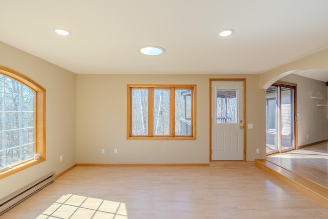 entrance foyer featuring a baseboard radiator, healthy amount of natural light, arched walkways, and recessed lighting