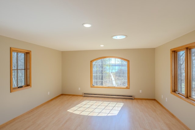 empty room with healthy amount of natural light, wood finished floors, baseboard heating, and recessed lighting