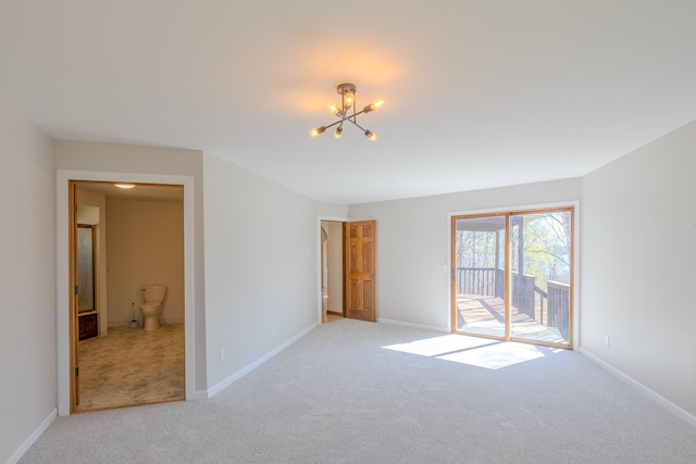 spare room with light carpet, a chandelier, and baseboards