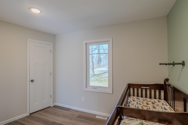 bedroom featuring wood finished floors, baseboards, and recessed lighting