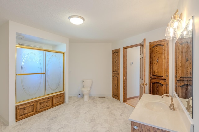 full bath with toilet, an enclosed shower, vanity, and baseboards