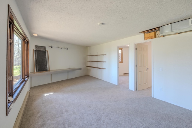 carpeted empty room featuring healthy amount of natural light and a textured ceiling