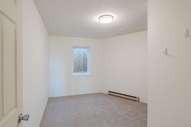 empty room with a baseboard radiator, a textured ceiling, and carpet flooring