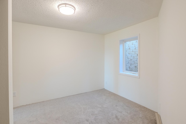 carpeted empty room featuring a textured ceiling