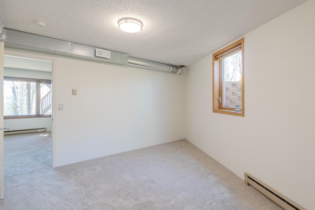 basement featuring baseboard heating, carpet flooring, and a textured ceiling