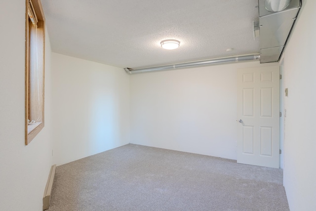 spare room featuring carpet and a textured ceiling