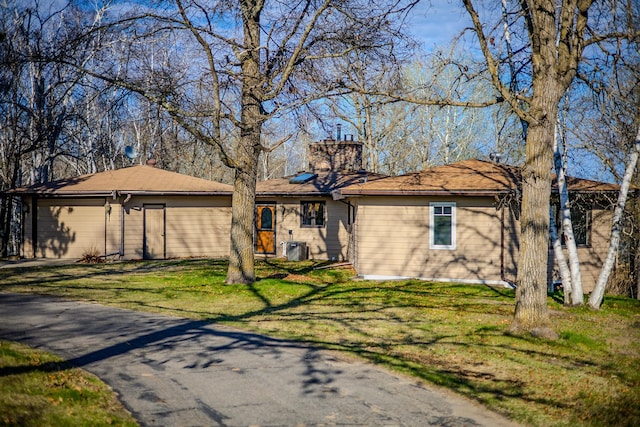 ranch-style house with an attached garage, asphalt driveway, and a front yard