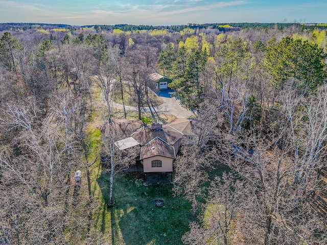 aerial view of property and surrounding area featuring a heavily wooded area