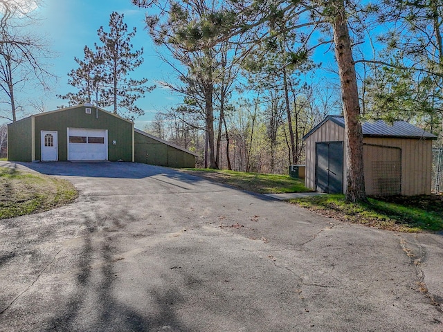 detached garage featuring asphalt driveway