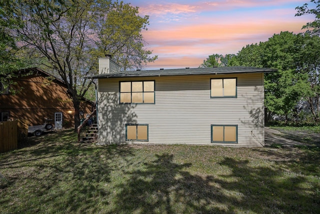 6522 Kilmer Ln N, Maple Grove, MN 55369 - back of property at dusk with stairway, a chimney, and a yard