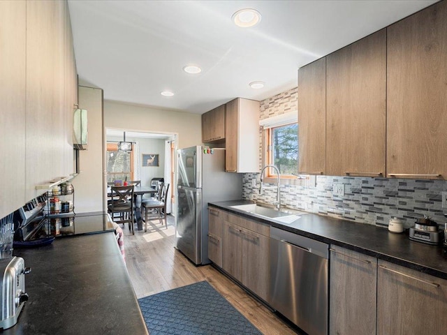 15921 Eaglewood Dr, Bay Lake Twp, MN 56444 - kitchen with stainless steel appliances, a sink, dark countertops, decorative backsplash, and recessed lighting