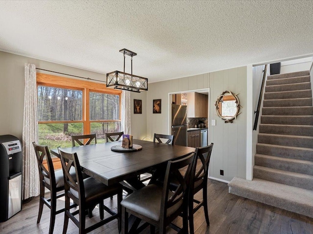 15921 Eaglewood Dr, Bay Lake Twp, MN 56444 - dining room featuring stairs, dark wood-style flooring, a chandelier, and a textured ceiling