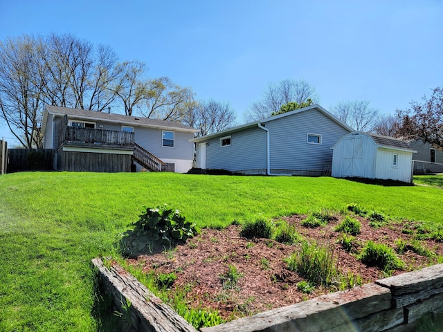 view of yard with stairway, an outdoor structure, a storage unit, and a deck