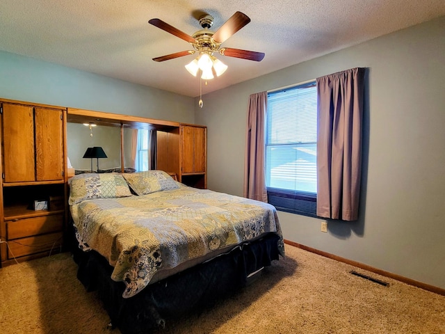 carpeted bedroom featuring baseboards and ceiling fan