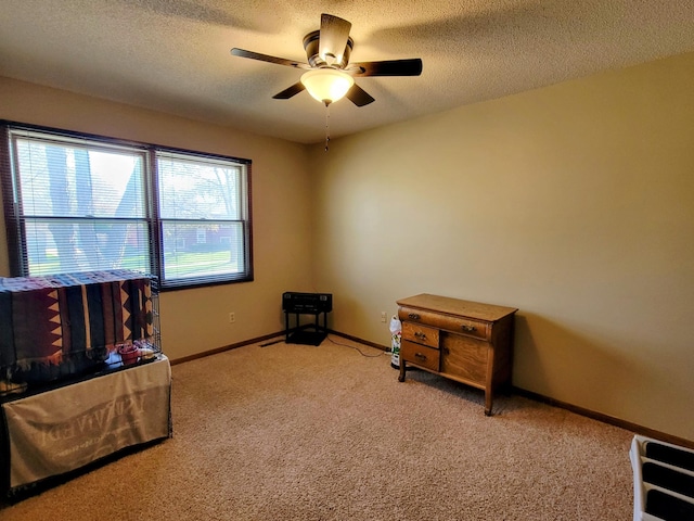 carpeted bedroom featuring a textured ceiling, baseboards, and a ceiling fan