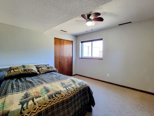 carpeted bedroom featuring baseboards, a closet, a ceiling fan, and a textured ceiling