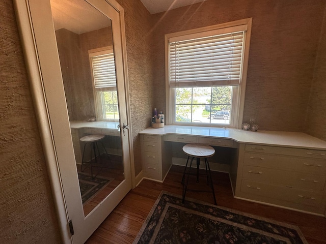 office with built in study area, dark wood-style flooring, and healthy amount of natural light