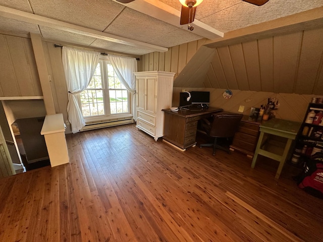 office area with a baseboard radiator, ceiling fan, dark wood-style flooring, and wooden walls