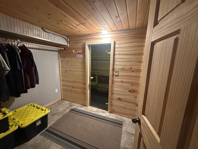 mudroom featuring wood walls, wood ceiling, and baseboards