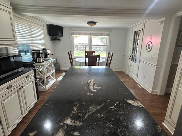 dining area with baseboards, dark wood-style floors, and a textured ceiling