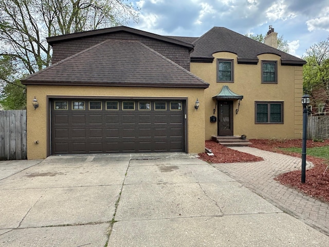 french country style house featuring stucco siding, concrete driveway, a chimney, and fence