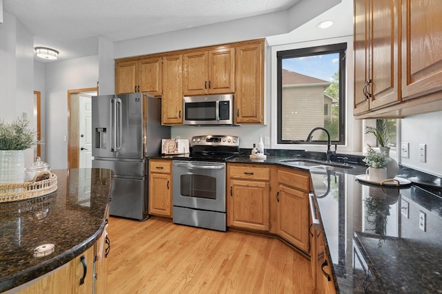 4255 Wexford Way, Eagan, MN 55122 - kitchen featuring stainless steel appliances, light wood-style floors, dark stone counters, and brown cabinets