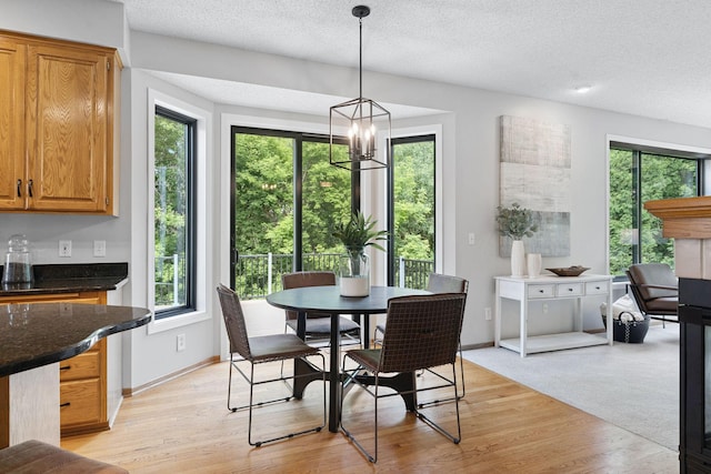 4255 Wexford Way, Eagan, MN 55122 - dining room with light wood-type flooring, a textured ceiling, and a chandelier