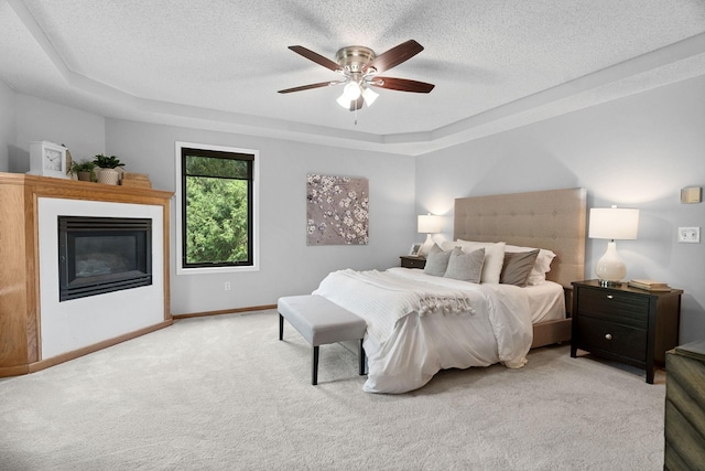 4255 Wexford Way, Eagan, MN 55122 - carpeted bedroom featuring a raised ceiling, a glass covered fireplace, a textured ceiling, and a ceiling fan