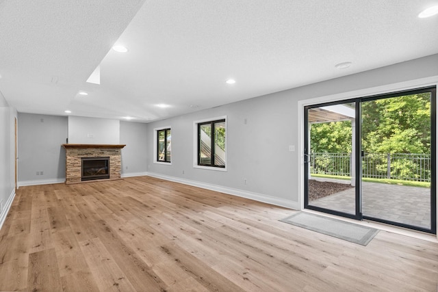 4255 Wexford Way, Eagan, MN 55122 - unfurnished living room with light wood finished floors, healthy amount of natural light, recessed lighting, a stone fireplace, and a textured ceiling