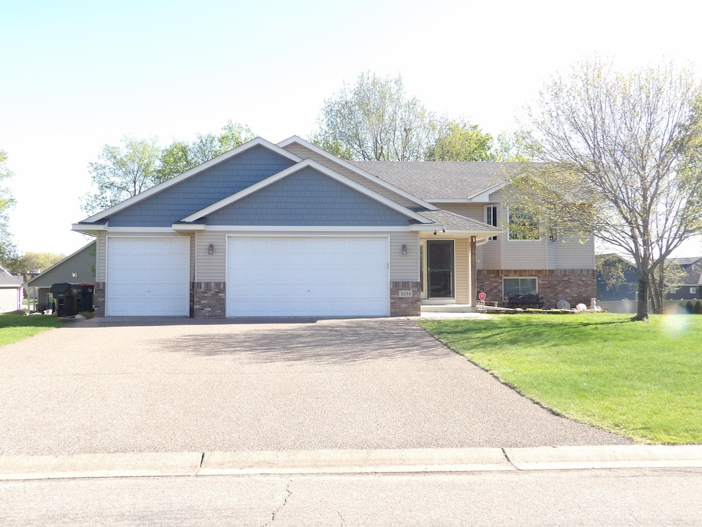 view of front of house with driveway, a front lawn, a garage, and brick siding