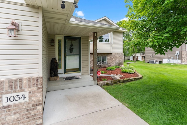 1034 111th Ave NE, Blaine, MN 55434 - property entrance with a yard, roof with shingles, cooling unit, and brick siding