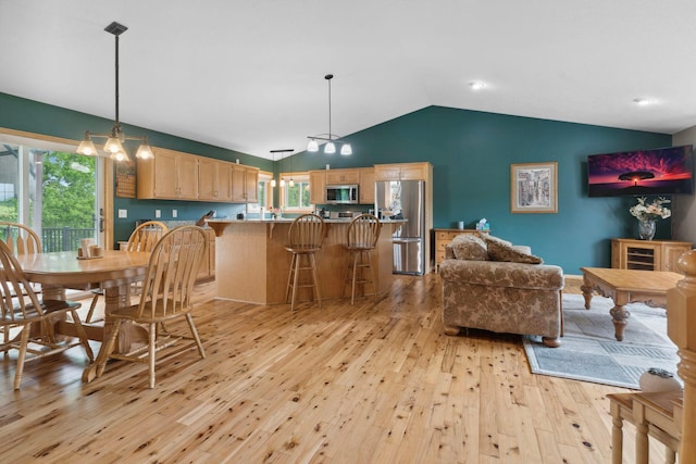 1034 111th Ave NE, Blaine, MN 55434 - dining area with light wood-type flooring, vaulted ceiling, and a chandelier