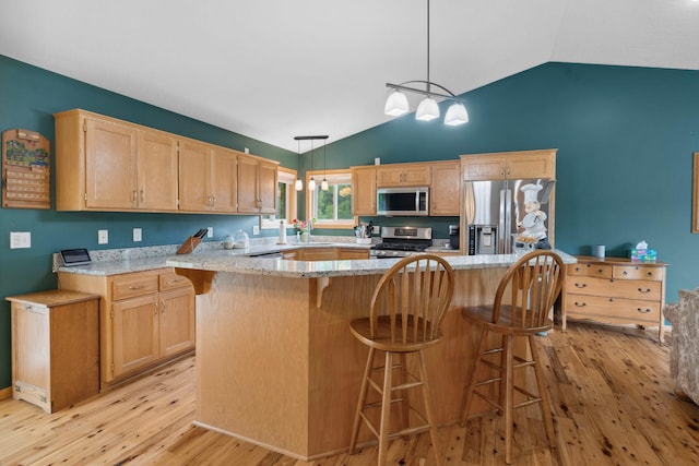 1034 111th Ave NE, Blaine, MN 55434 - kitchen featuring appliances with stainless steel finishes, light wood-style flooring, light brown cabinets, pendant lighting, and a center island