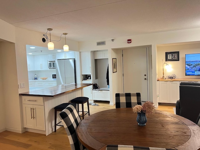 dining area featuring light wood-type flooring and baseboards