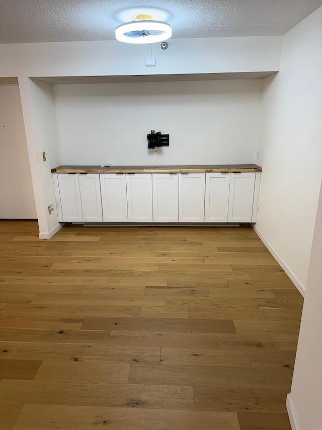 laundry room with light wood-style floors and baseboards