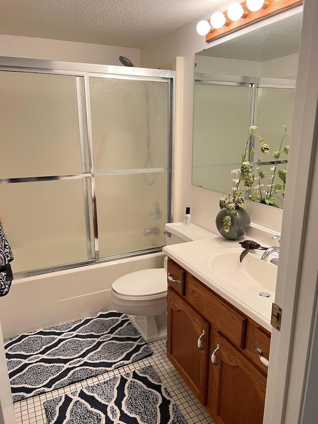 full bathroom featuring vanity, bath / shower combo with glass door, toilet, and tile patterned floors