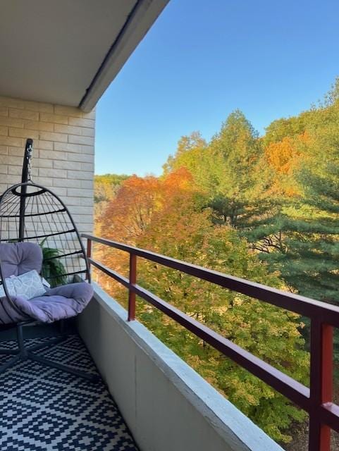 balcony featuring a wooded view