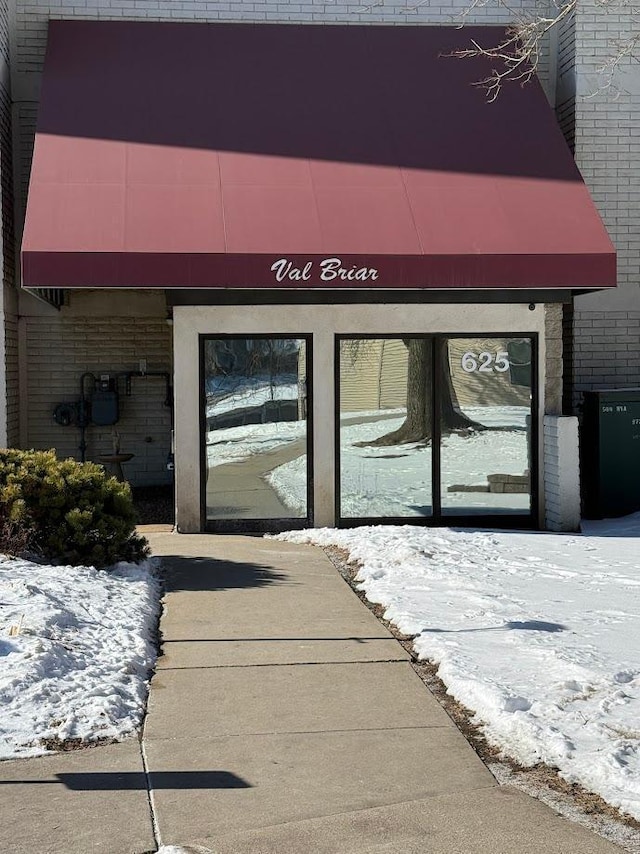 doorway to property with brick siding
