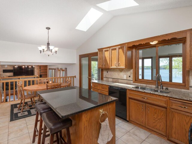 15825 Garden View Dr, Apple Valley, MN 55124 - kitchen with black dishwasher, a sink, a skylight, brown cabinetry, and backsplash