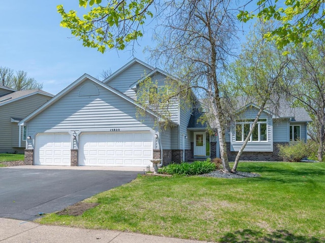 15825 Garden View Dr, Apple Valley, MN 55124 - view of front of property with a garage, a front lawn, brick siding, and driveway