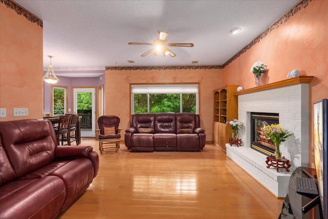 9230 Cheney Trl, Inver Grove Heights, MN 55076 - living room with a ceiling fan, light wood-type flooring, a textured ceiling, and a fireplace