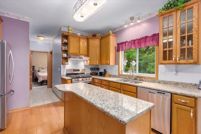 9230 Cheney Trl, Inver Grove Heights, MN 55076 - kitchen featuring stainless steel appliances, a sink, under cabinet range hood, a kitchen island, and decorative backsplash