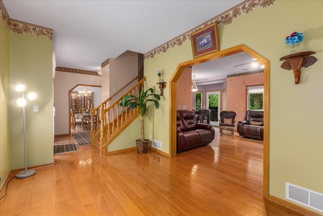 9230 Cheney Trl, Inver Grove Heights, MN 55076 - entryway with wood finished floors, baseboards, stairs, arched walkways, and a chandelier